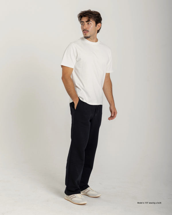 Short Man wearing a white t-shirt and black pants on a plain background