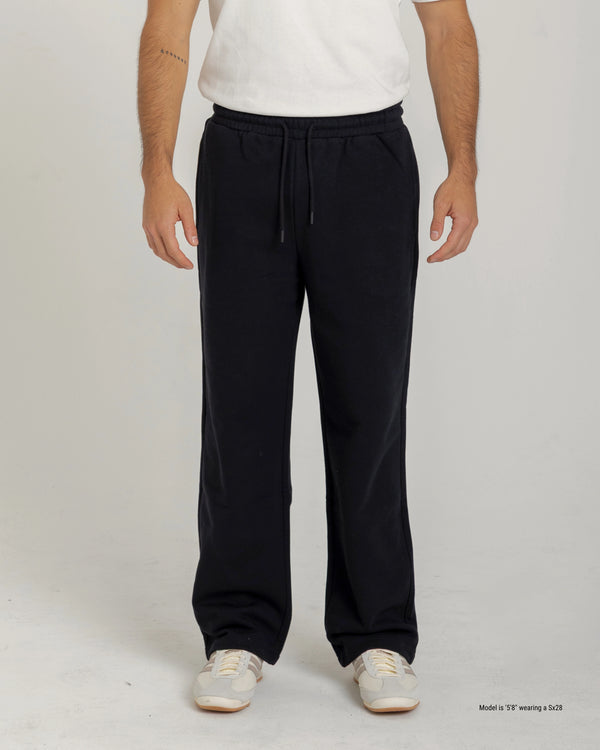 Short Person wearing black sweatpants and a white shirt on a plain background