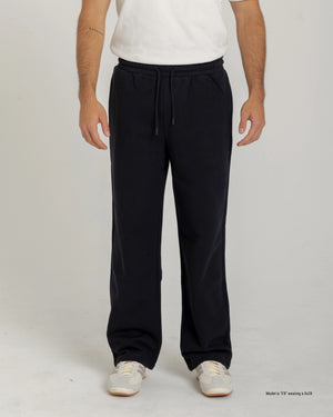 Short Man wearing a white t-shirt and black pants on a plain background