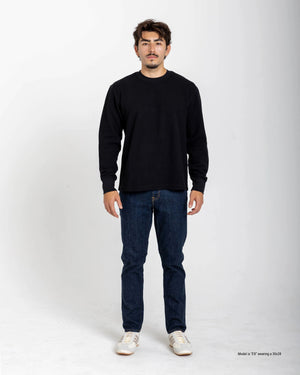 Shorter Man wearing a blue t-shirt and light blue jeans on a white background