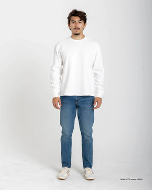 Shorter Man wearing a blue t-shirt and light blue jeans on a white background
