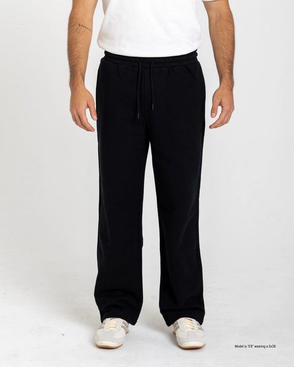 Shorter Person wearing black drawstring pants on a white background