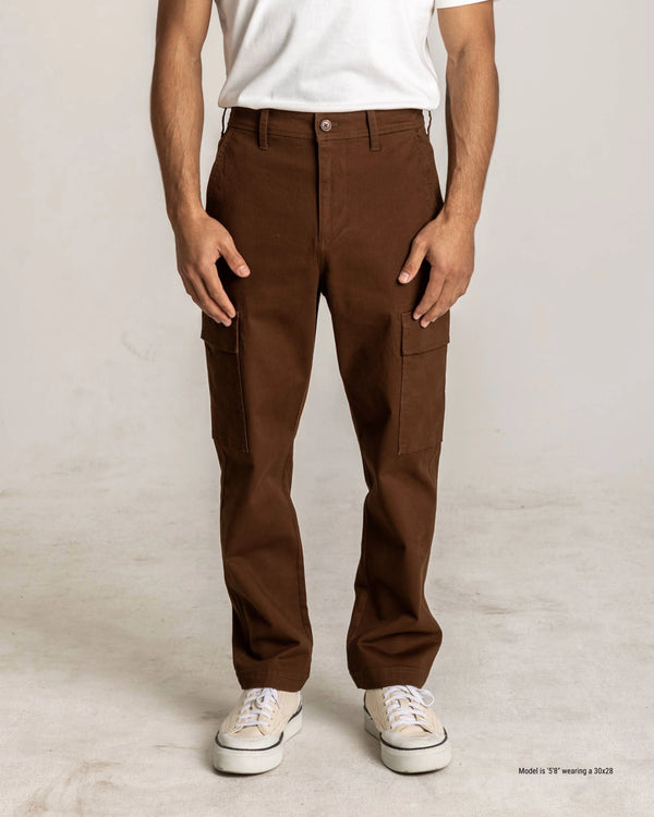 Person wearing brown cargo pants on a plain background