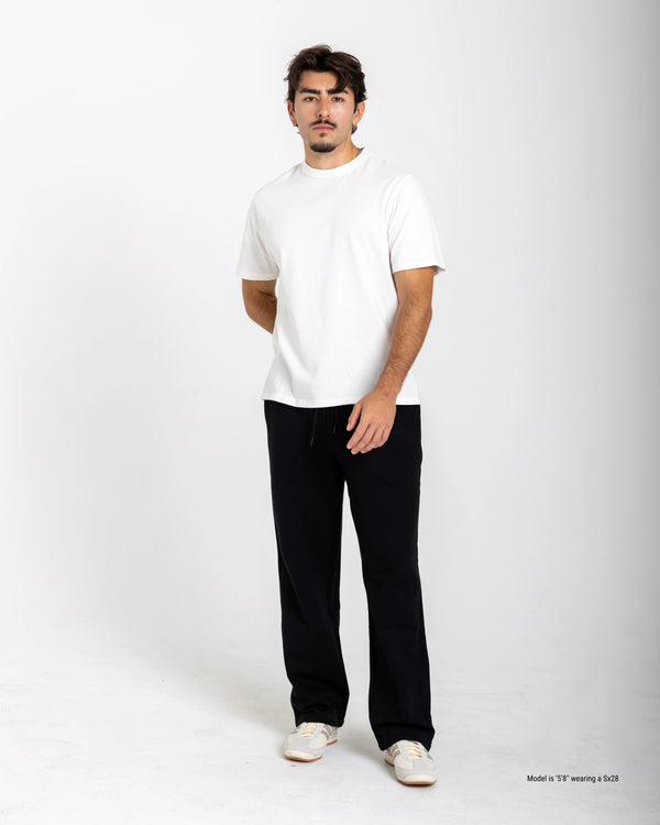 Man wearing a white t-shirt and black sweatpants on a white background
