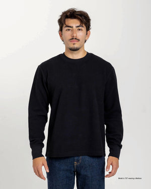 Short Man wearing a blue textured waffle shirt against a plain background